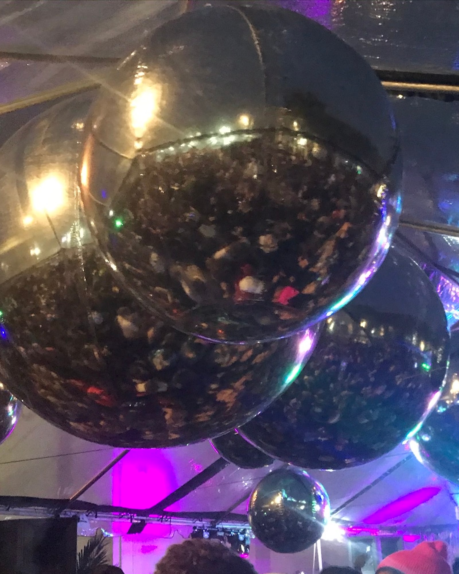 Mirror balls hanging over a crowded dance floor